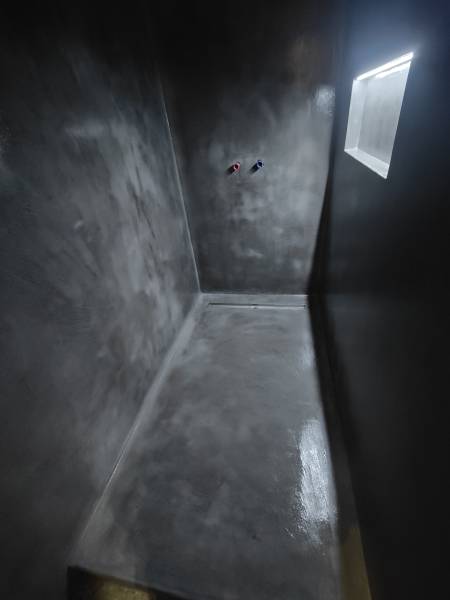 Revêtement minéral en béton ciré, sans joint et facile d'entretien, pour un rendu minéral unique, moderne et contemporain sur le sol et murs d'une douche à Offlanges proche de Dole dans le Jura-BR HOME