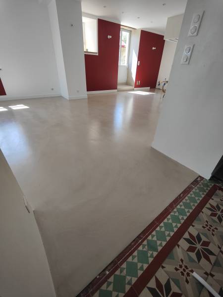 Recouvrement d'une chape ciment avec mortier bi-composant en béton ciré taloché, composé de poudre de ciment pré teintée avec des pigment minéraux naturels et de résine, appliquer manuellement pour des nuances de profondeur et  élégante dans une cuisine, 