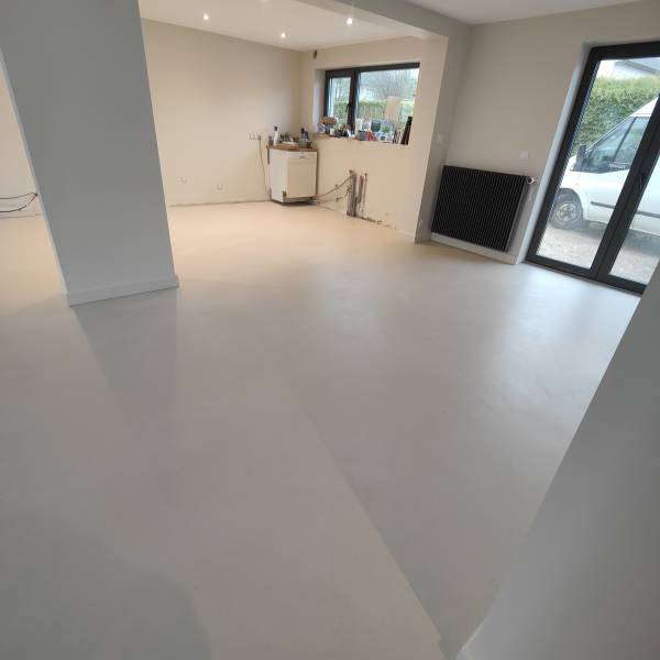 Revêtement de sol en béton ciré, pour un rendu élégant, contemporain et minimaliste à la texture minérale et aux nuances légères. Sans joints et facile d'entretient dans une cuisine, salon, sale à manger, entrée à Besançon dans le Doubs- BR HOME
