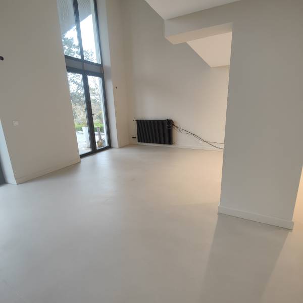 Revêtement en béton ciré composé de poudre de ciment pré teintée avec des pigments minéraux naturels, et de résine, appliquer manuellement sur support chape ciment. Pour une texture minéral à la finition mat dans une cuisine, salon, salle à manger, entrée