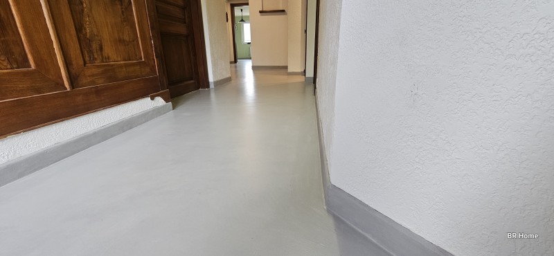 Revêtement en béton ciré, facile d'entretient sans joint, à l'aspect minéral finition mat, aux nuances élégante, moderne et contemporaine dans une cuisine, salle de bain, couloir et toilettes à Villers le Lac proche de Morteau dans le Doubs- BR HOME